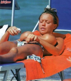 9. Anna Falchi – Topless sunbathing