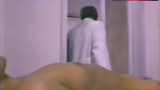 2. Femi Benussi Lying Topless on Table – The Slasher Is The Sex Maniac